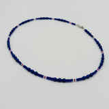 Blue beaded necklace on a light gray background